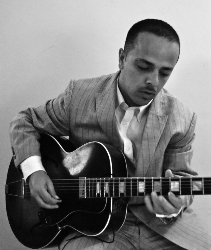 A man playing guitar in black and white