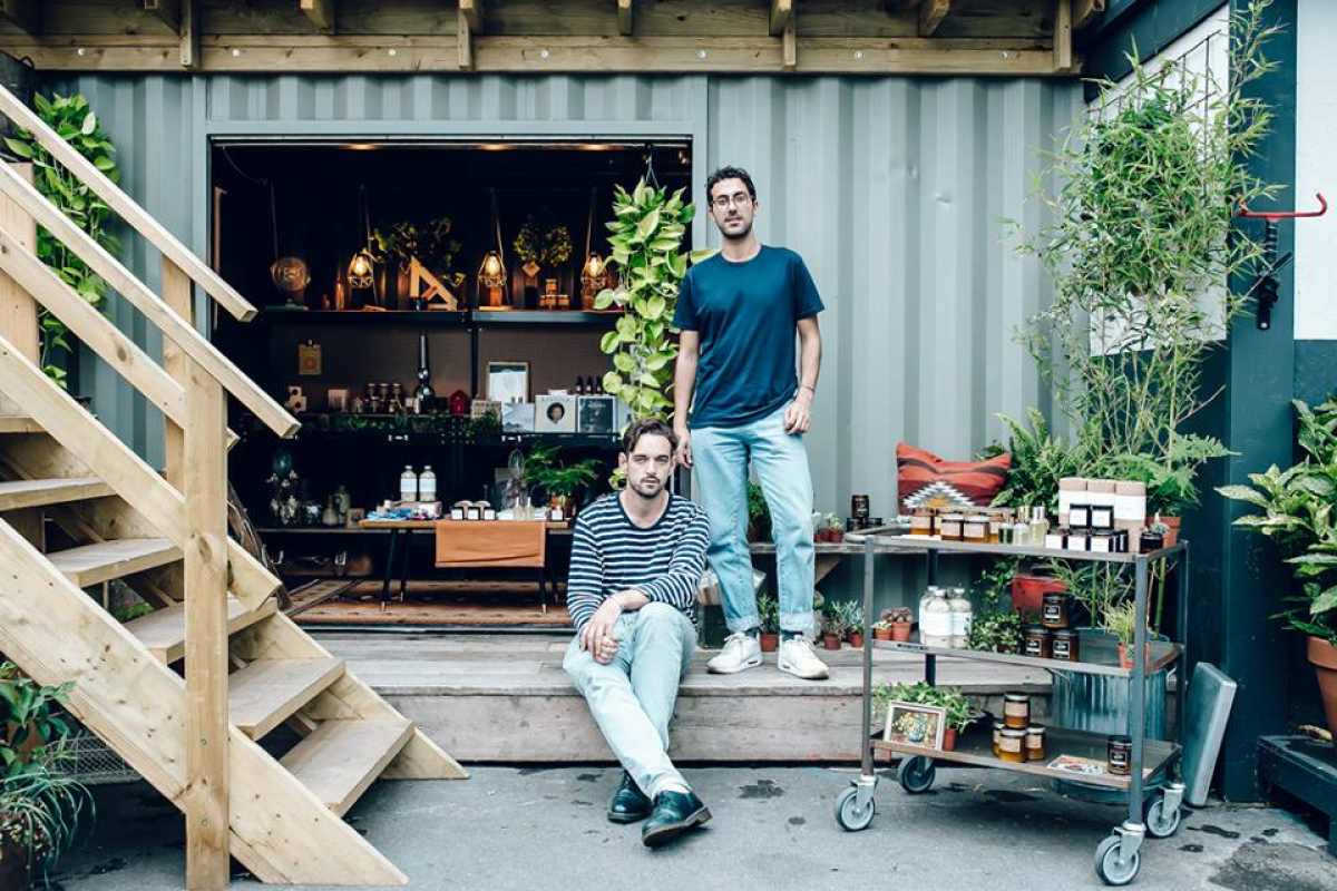 Two men standing in front of the market shop at Netil Market in Hackney on a warm day