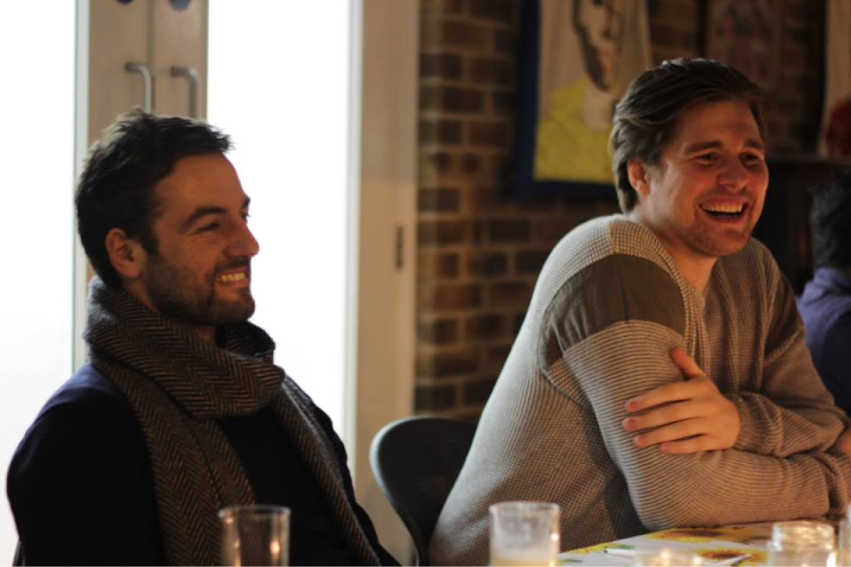 Marc Sethi and Kitt Proudfoot smiling and relaxed in low lit room at Pitch It! creative mentoring supper club.