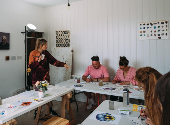 Creative residents taking part in a watercolour painting class inside a bright, minimal studio space at Alma Yard, Plymouth.