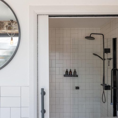 Modern tiled shower facilities at Alma Yard, Plymouth, designed for comfort and convenience of residents with minimal aesthetic.