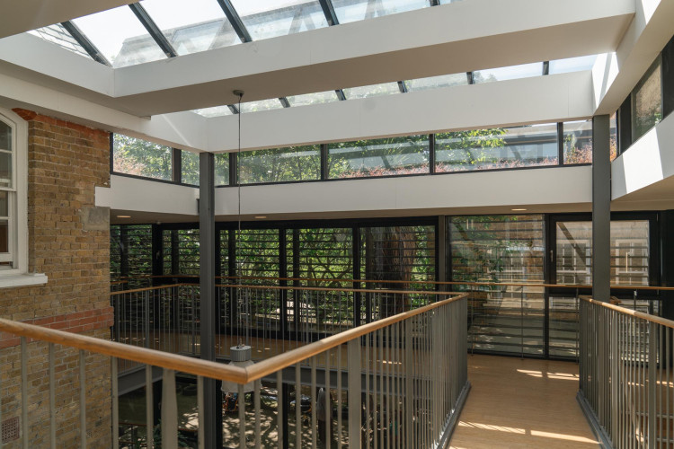 Bright communal lobby at Cornerstone Studios featuring skylights, indoor greenery and architectural detailing