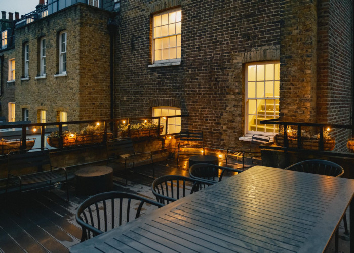 Terrace at Cornerstone Studios with evening lighting, outdoor seating and warm-lit Georgian windows