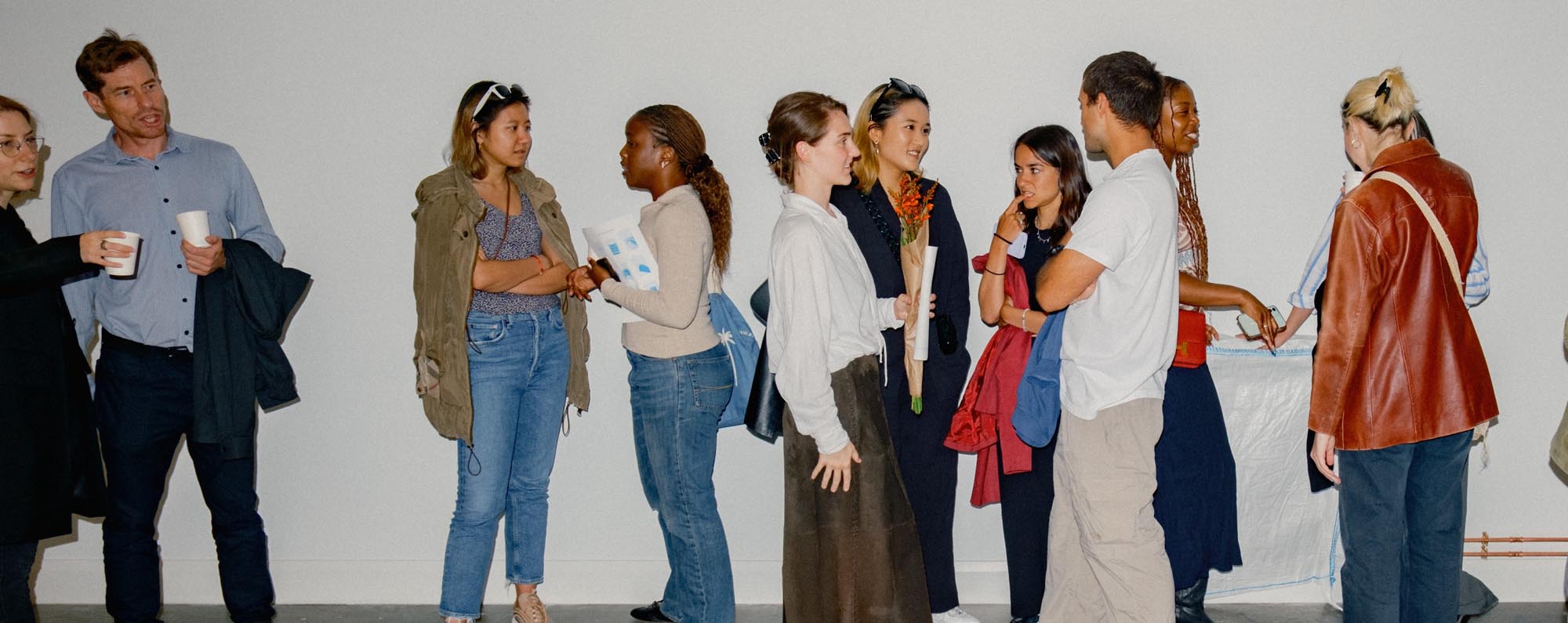 Attendees in conversation at an Eat Work Art networking event, connecting creatives and residents