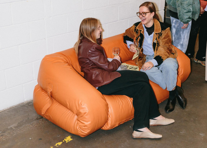 Conversation between creatives seated on a sculptural orange sofa at Hackney Downs Studios