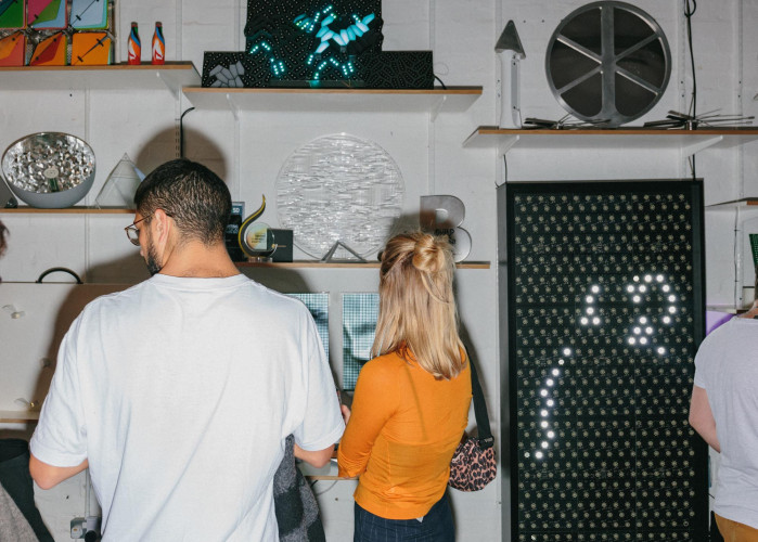 Visitors interacting with illuminated sculptures and digital installations during open studio evening