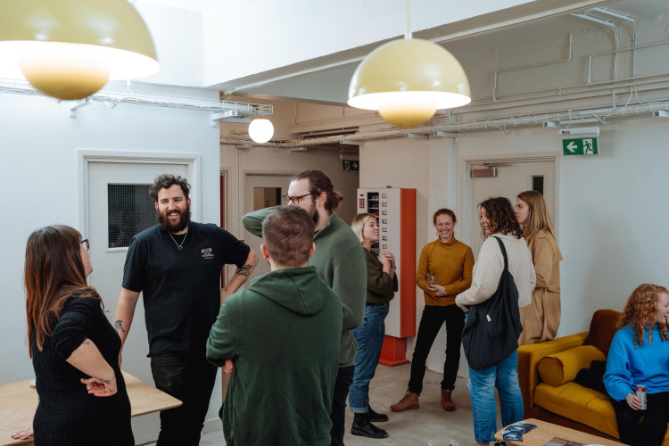Creative residents gathering for a social event at Light Studios Plymouth, set in a modern and welcoming communal area