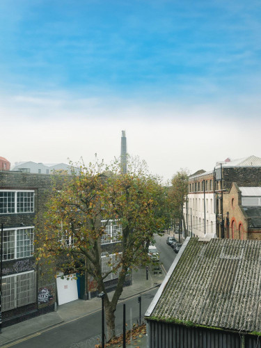 Street-level view from Lockside Studios London overlooking Hackney’s creative quarter, with industrial buildings and autumn trees