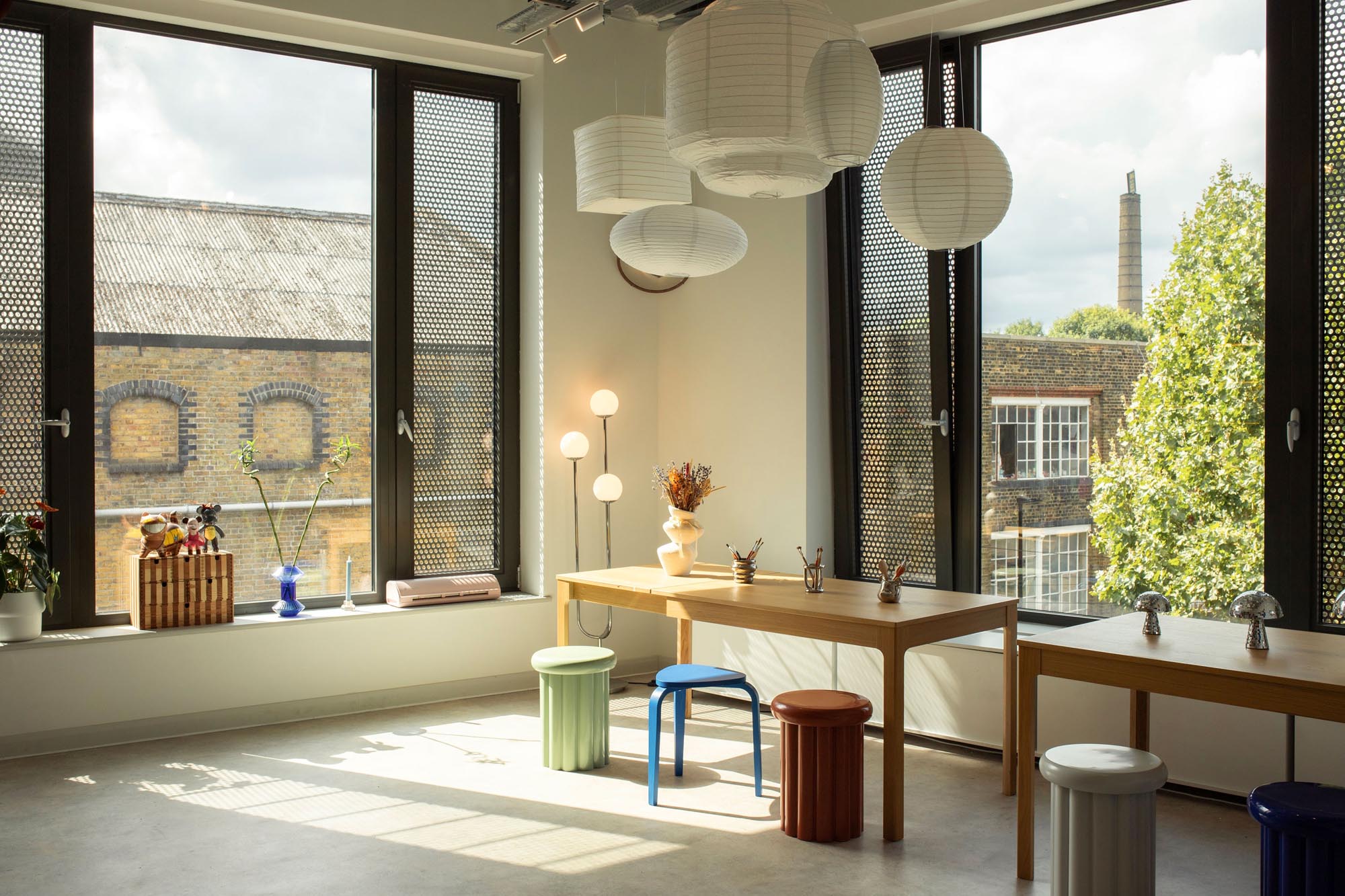 Bright and design-led studio interior at Lockside Studios London, featuring contemporary furniture, sculptural lighting and views of Hackney’s industrial architecture