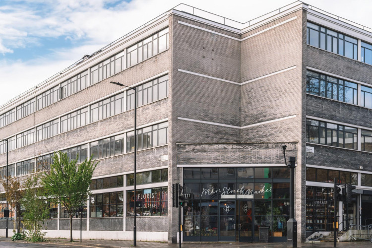 Exterior of Netil Corner in London, a prominent creative workspace and retail hub located above Mare Street Market with large industrial windows and grey brick facade