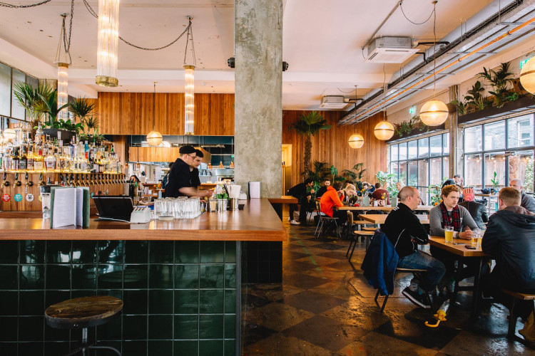 Interior of Mare Street Market at Netil Corner London, showcasing a vibrant bar area with tiled finishes and a buzzing atmosphere