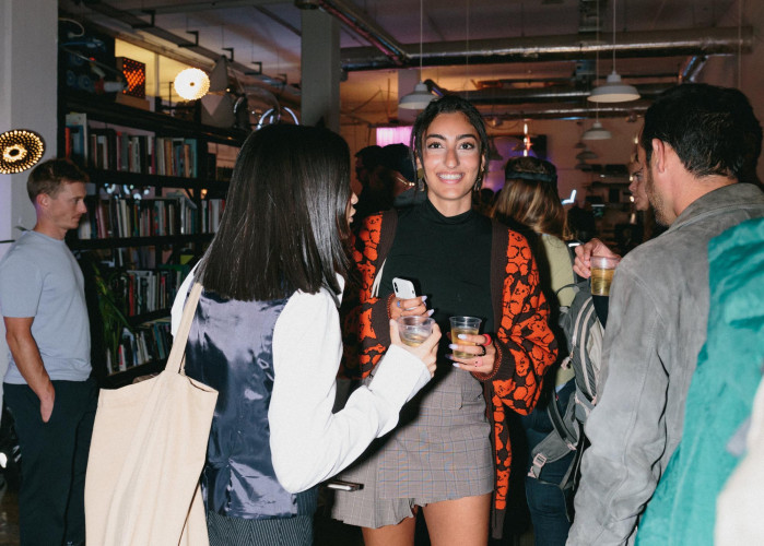 Guests enjoying a night event at Netil House with bookshelves, ambient lighting and an eclectic mix of creative residents