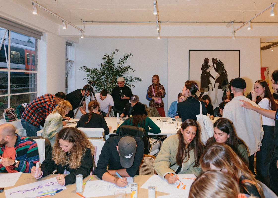 Creative professionals participating in a collaborative workshop at a coworking space, surrounded by art, natural light and a lively community atmosphere.