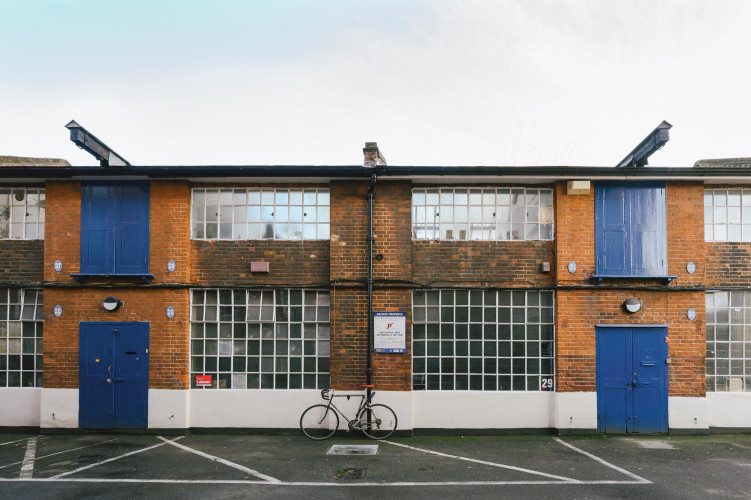 Exterior of Sunbury Workshops with classic brick facade, big windows and bicycle parked outside