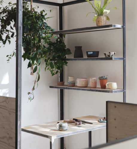 Natural light-filled coworking space with custom steel structures and plants at Hackney Downs Studios