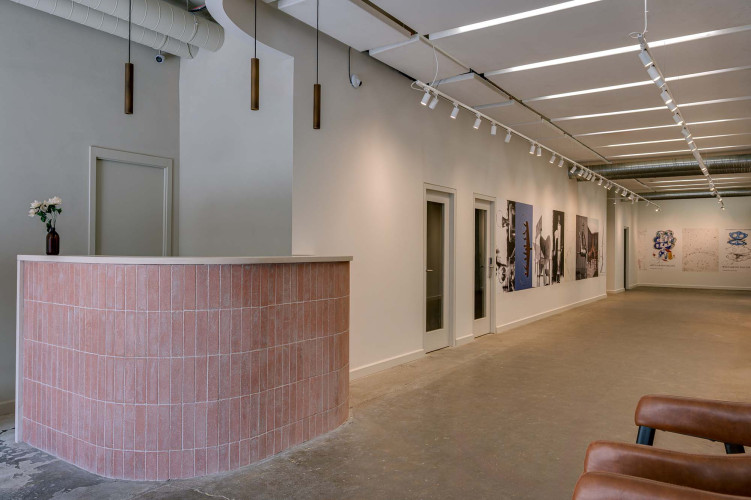 Minimalist reception area with sculptural lamps and gallery space inside Hackney Downs Studios