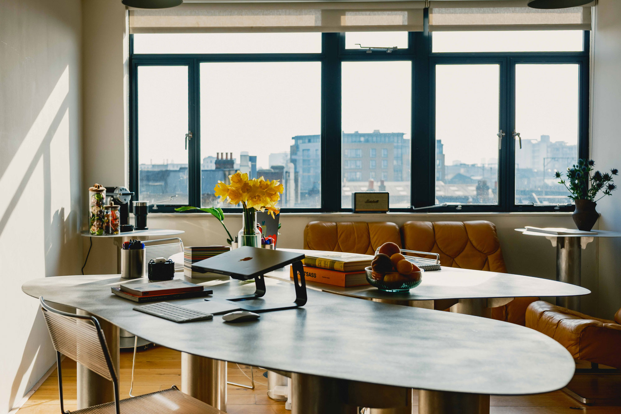 Bright workspace at Netil Corner featuring curved desk design and skyline backdrop through large windows