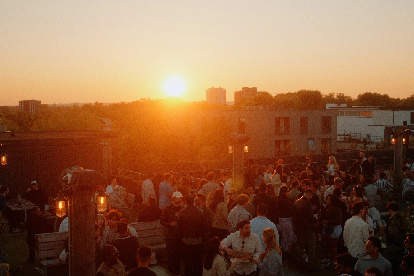 Crowd enjoying sunset drinks on the Netil360 rooftop bar in East London.